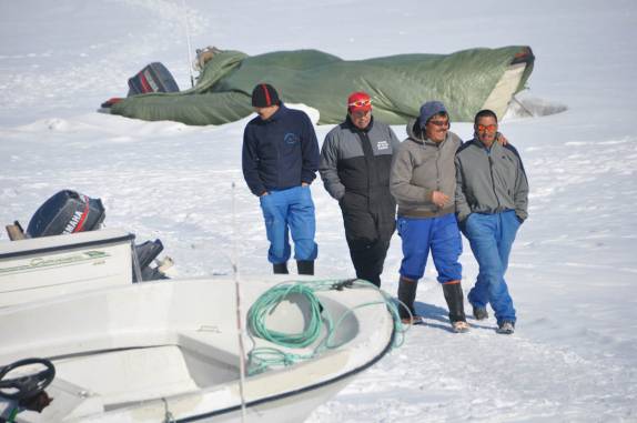 Portuários caminham felizes sobre o mar congelado no porto de Ilulissat, na Groelândia